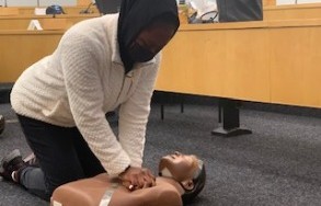 Woman performing CPR on dummy