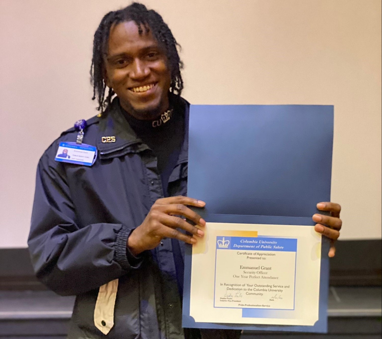 Security Officer Emmanuel Grant Celebrates 1 Year of Perfect Attendance man in Public Safety uniform holding up a perfect attendance certificate
