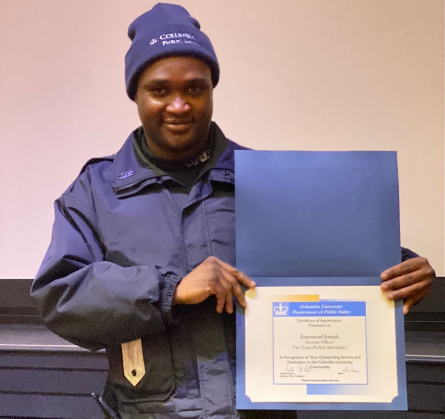 Security Officer Emmanuel Joseph Celebrates 1 Year of Perfect Attendance man in Public Safety uniform holding up a perfect attendance certificate