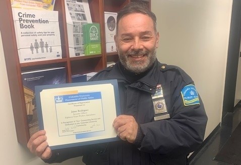 Security Officer Jaime Rodriguez Celebrates 18 Years of Perfect Attendance man in Public Safety uniform holding up perfect attendance certificate