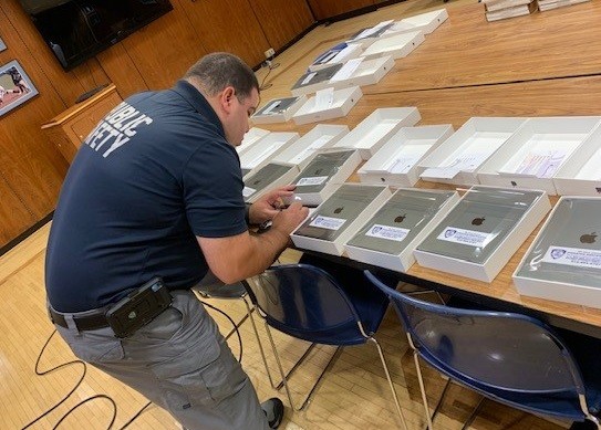 Public Safety team member engraving electronics iPads on a table