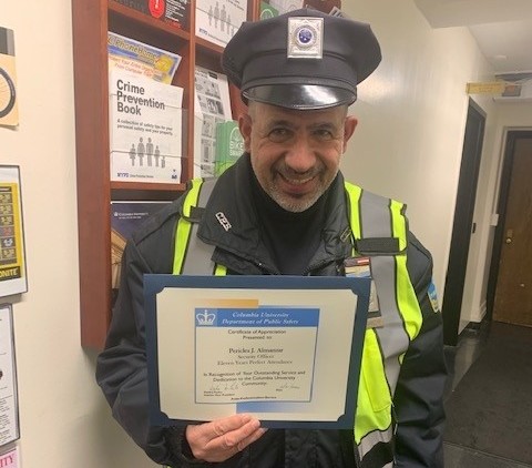 Security Officer Pericles Almanzar Celebrates 11 Years of Perfect Attendance photo of man in Public Safety uniform holding up perfect attendance certificate