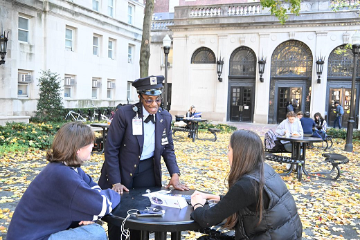 PSO female officer speaking to students in front of John Jay Hall