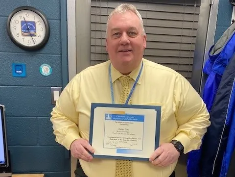 man holding up perfect attendance certificate