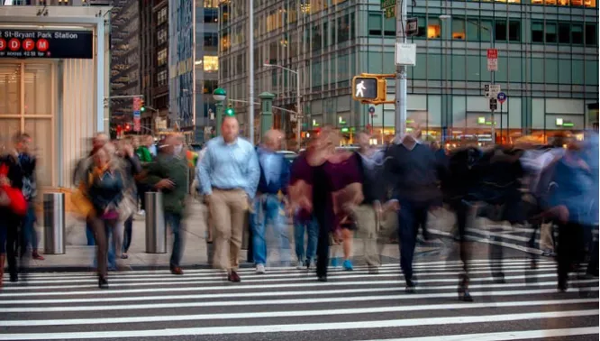 blurred image of group of people crossing NYC street