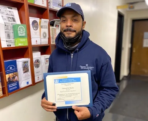 photo of man holding up perfect attendance certificate