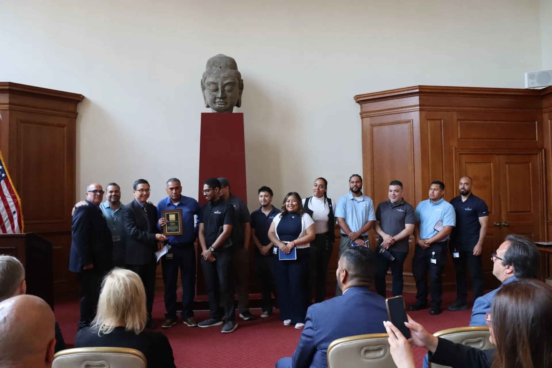 group poses for photo while Yiling holds an award