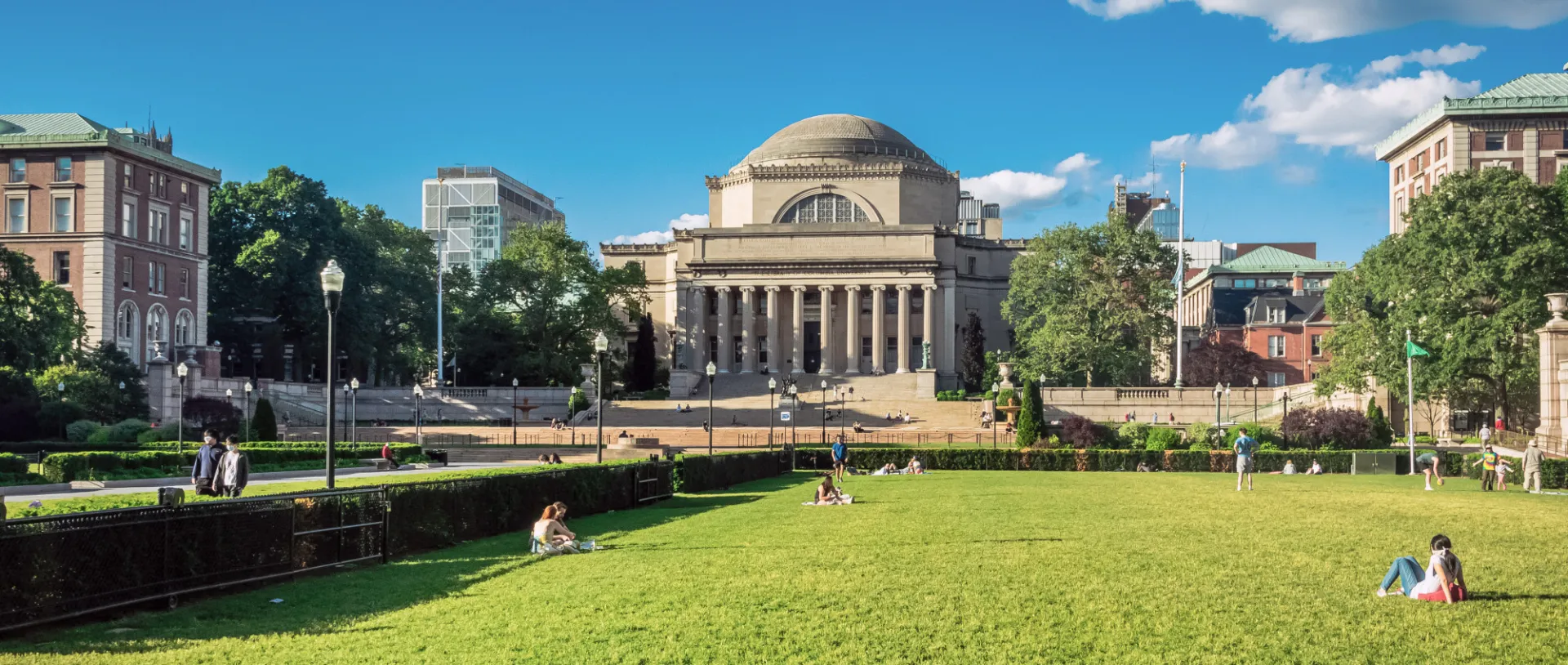 A view of people sitting on South Lawn with a view of College Walk, Low Library, and upper campus in the background.