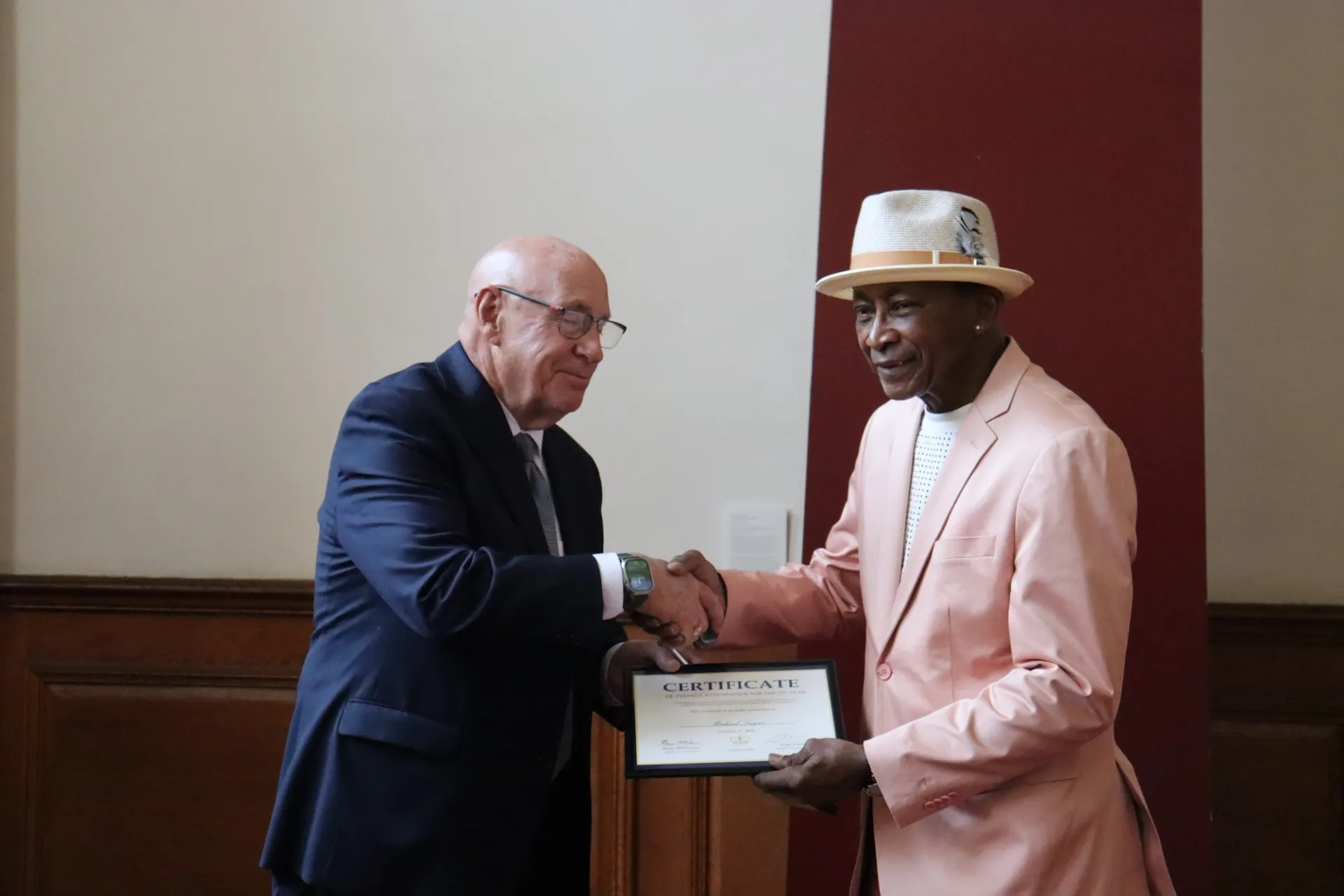 Michael Layne shaking hands as he receives a certificate